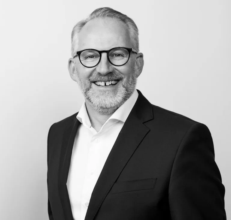 Hotelier Stefan Keel lächelt in Hemd und Jackett in die Kamera.